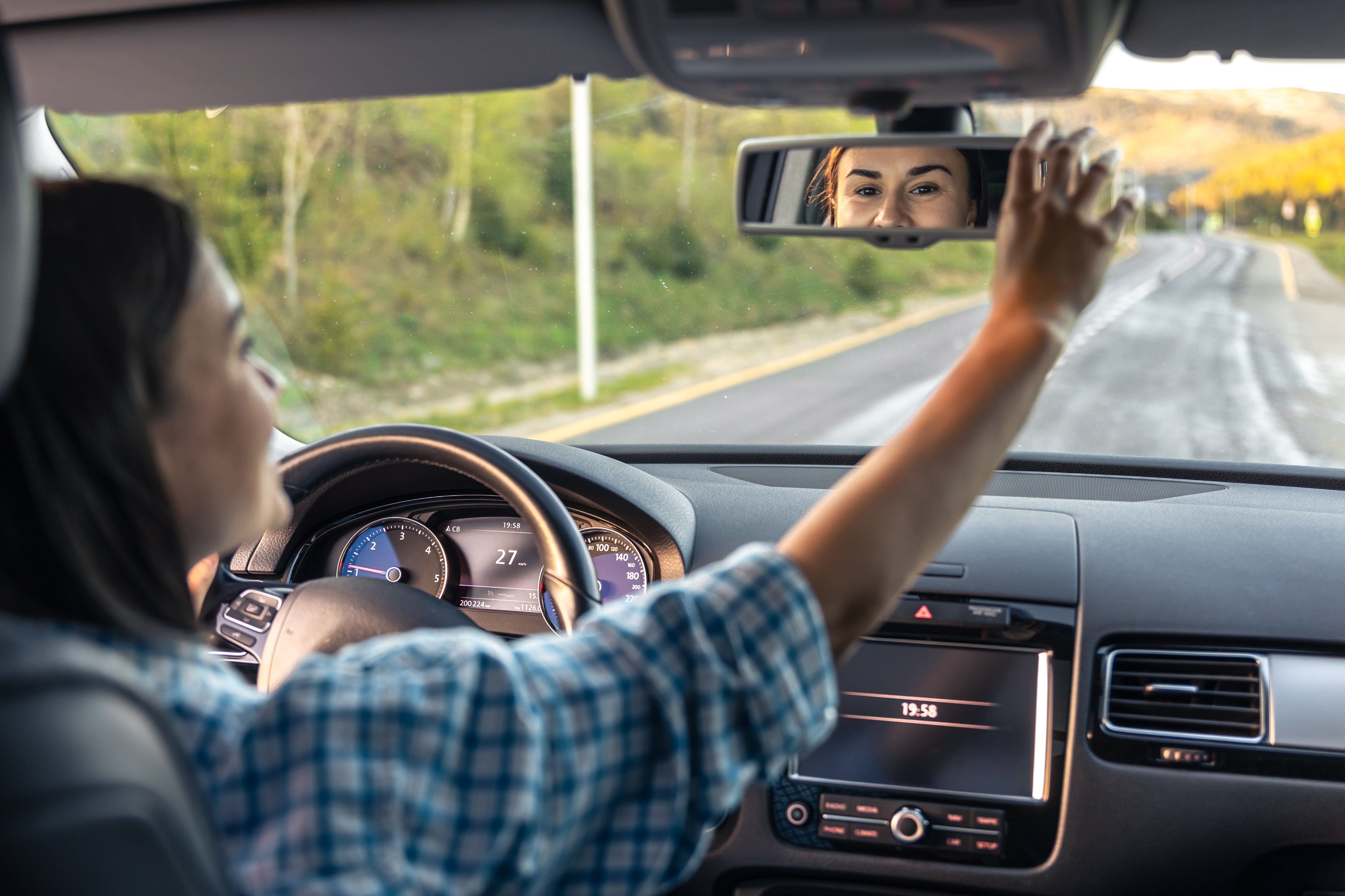 Driver behind the wheel of a car, hands on steering wheel, focused on safe driving on the road